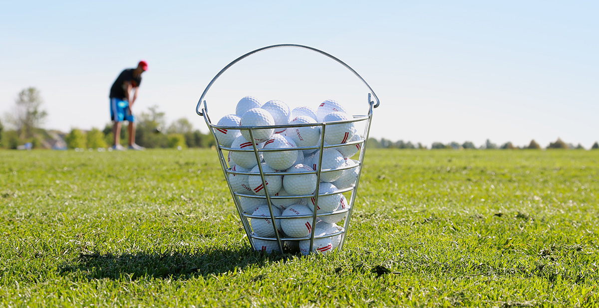 bucket of golf balls on driving range